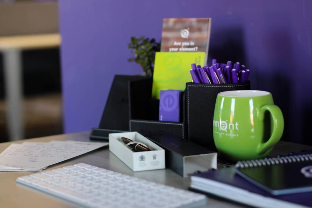 purple background with green-element-group-mug-on-a-desk